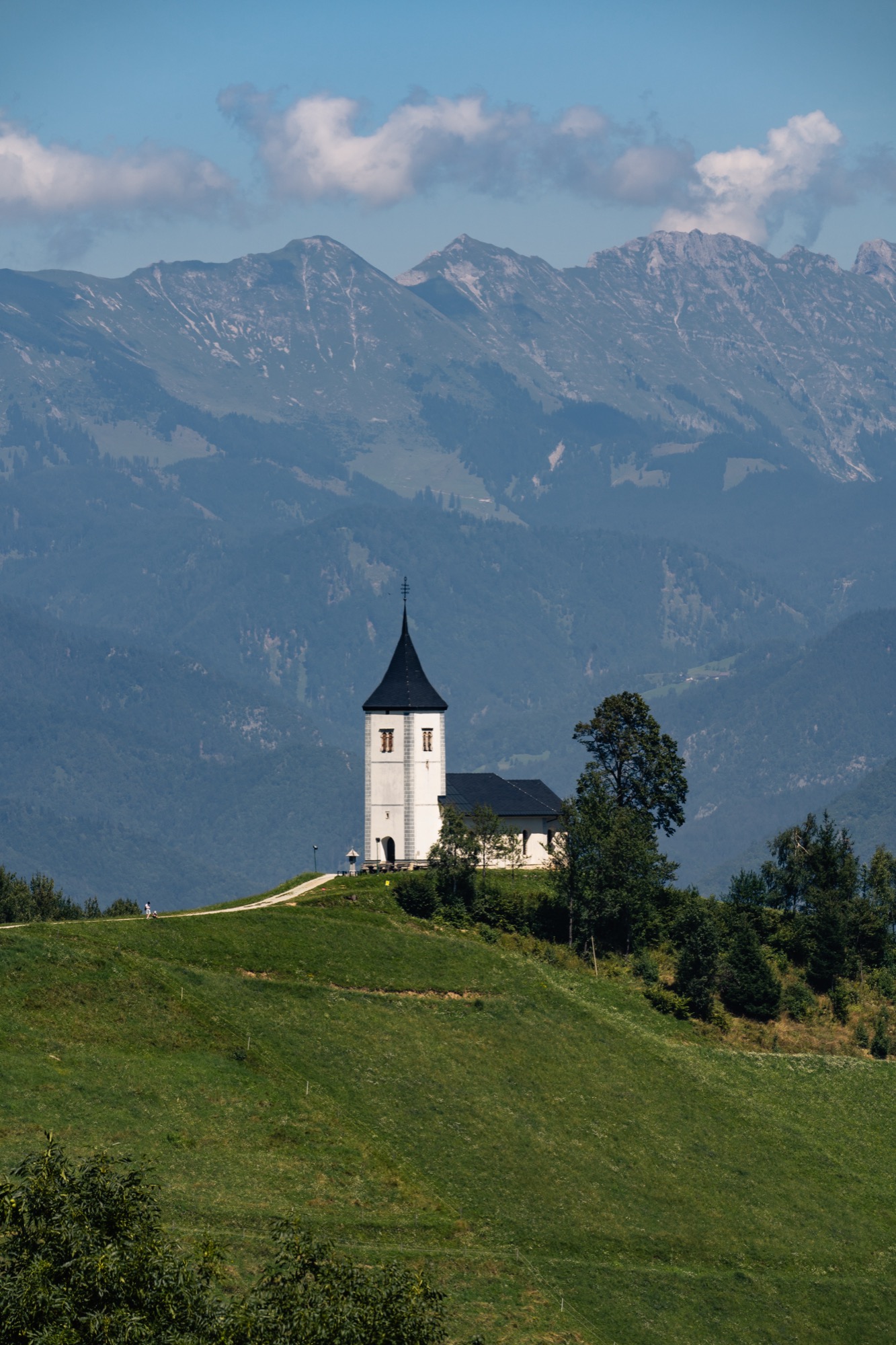 Church on a hill with mountains behind, Slovenia